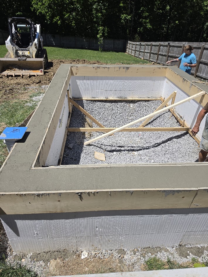 ICF pool walls with foam forms, bracing, and fresh concrete bond beam in a fenced Middle Tennessee backyard