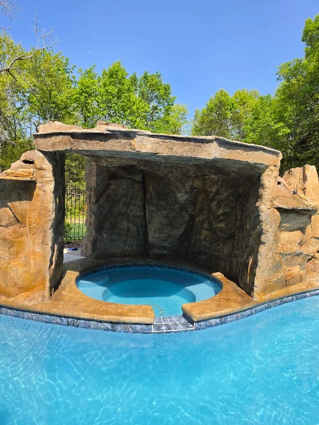 Spa and rock grotto beside a custom pool