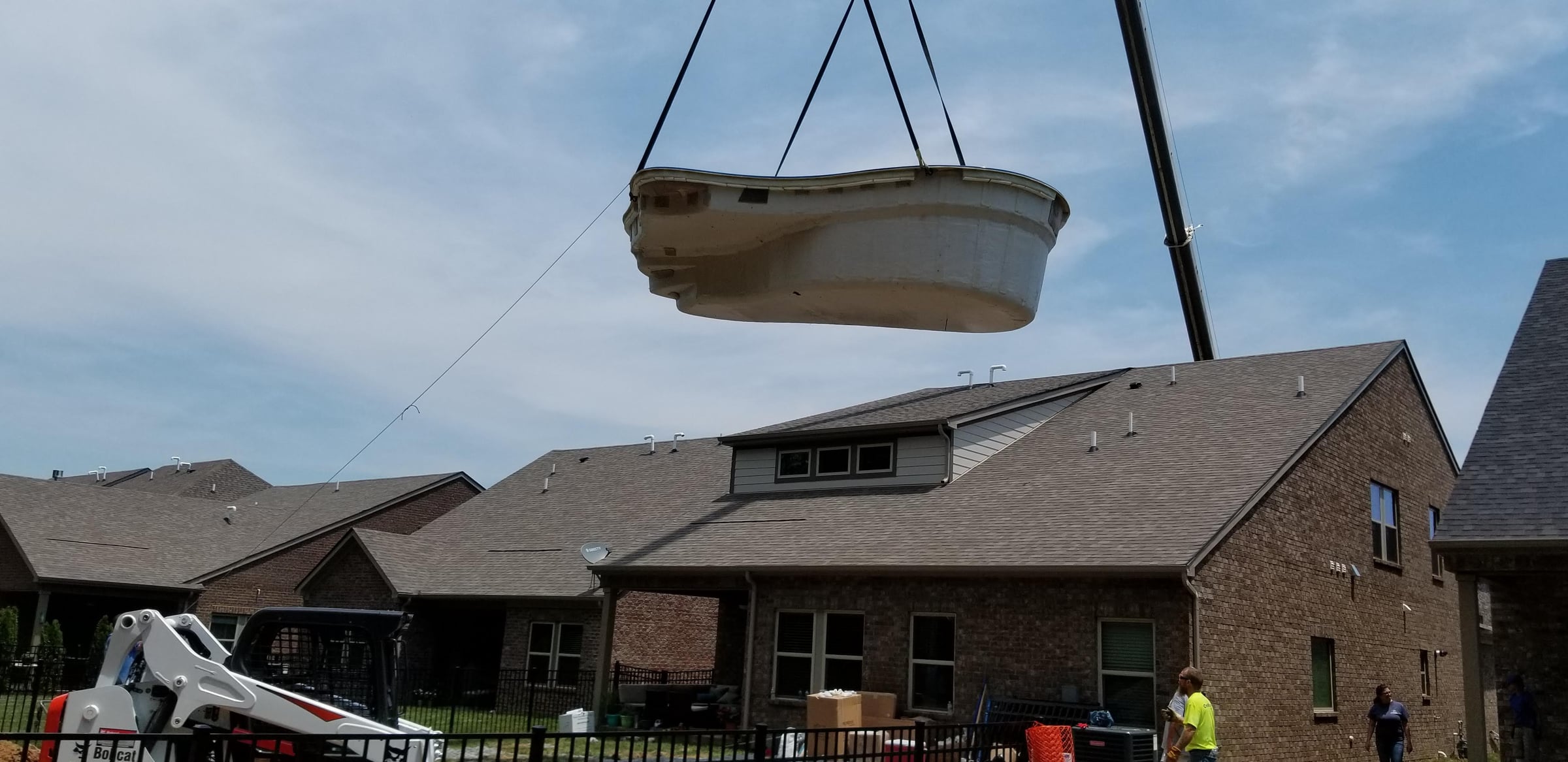 Fiberglass pool shell craned over the rooftops to a Middle Tennessee backyard